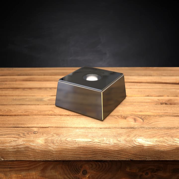 Square silver LED light base on a wooden table.